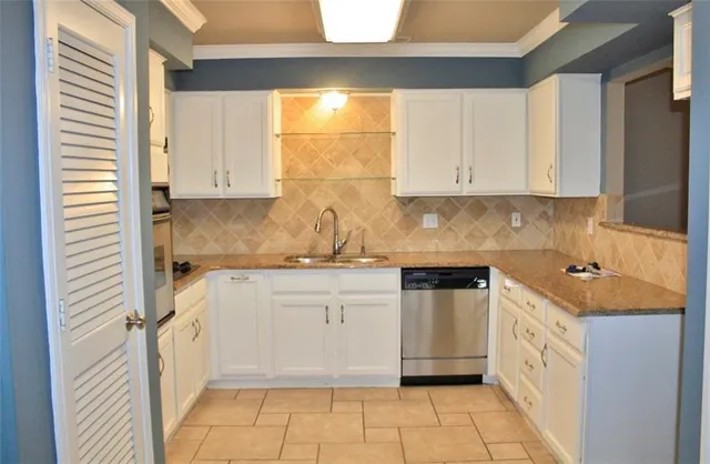 a kitchen with granite countertop white cabinets and white appliances