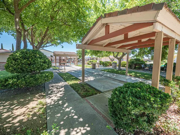 a front view of a house with a yard and potted plants