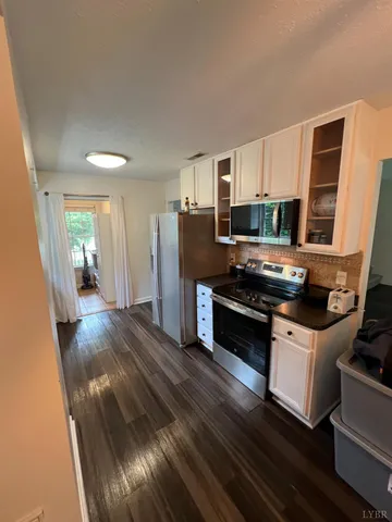 a kitchen with wooden floors and stainless steel appliances