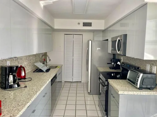 a kitchen with furniture a refrigerator and a stove