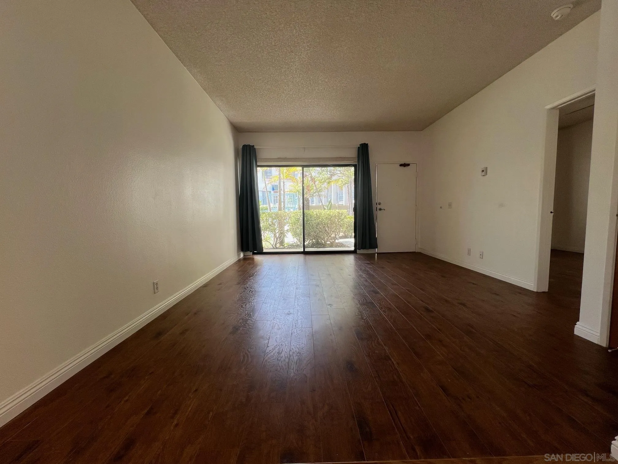 8310 Regents Road, Unit 1E San Diego, CA 92122 - Photo 4 of 23 a view of an empty room with wooden floor and a window