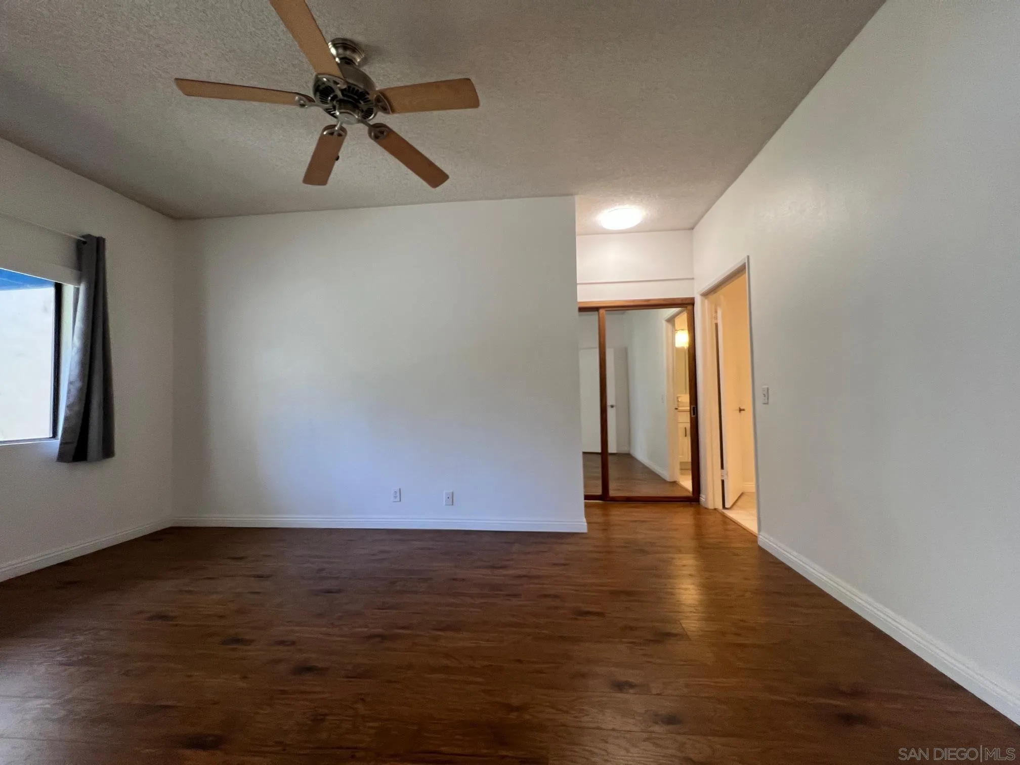8310 Regents Road, Unit 1E San Diego, CA 92122 - Photo 5 of 23 a view of an empty room with wooden floor