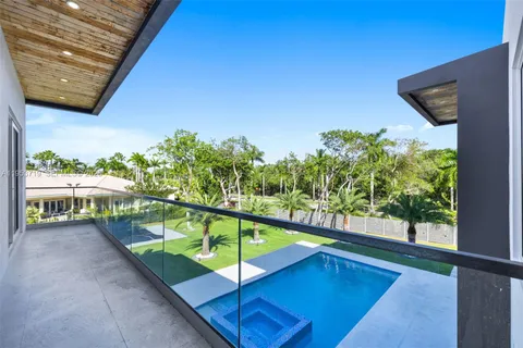 an aerial view of residential houses with outdoor space and trees