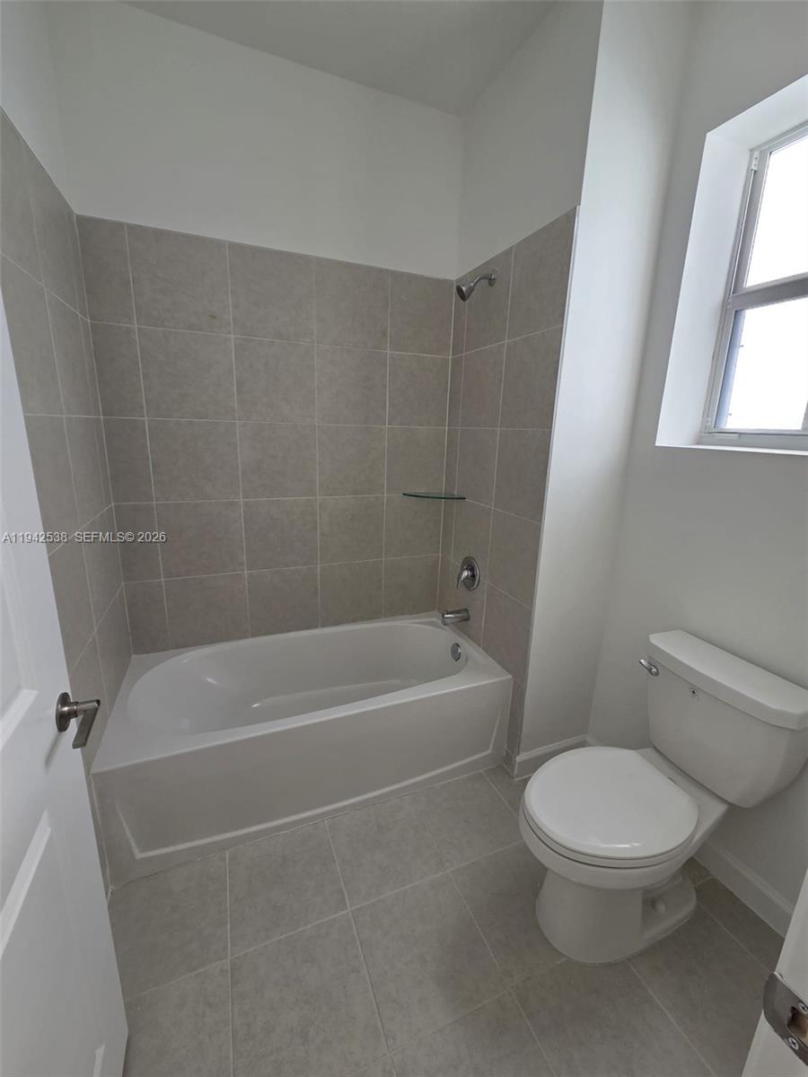 16303 Southwest 147th Place, Unit 16303 Miami, FL 33193 - Photo 16 of 37 a white toilet sitting next to a bath tub