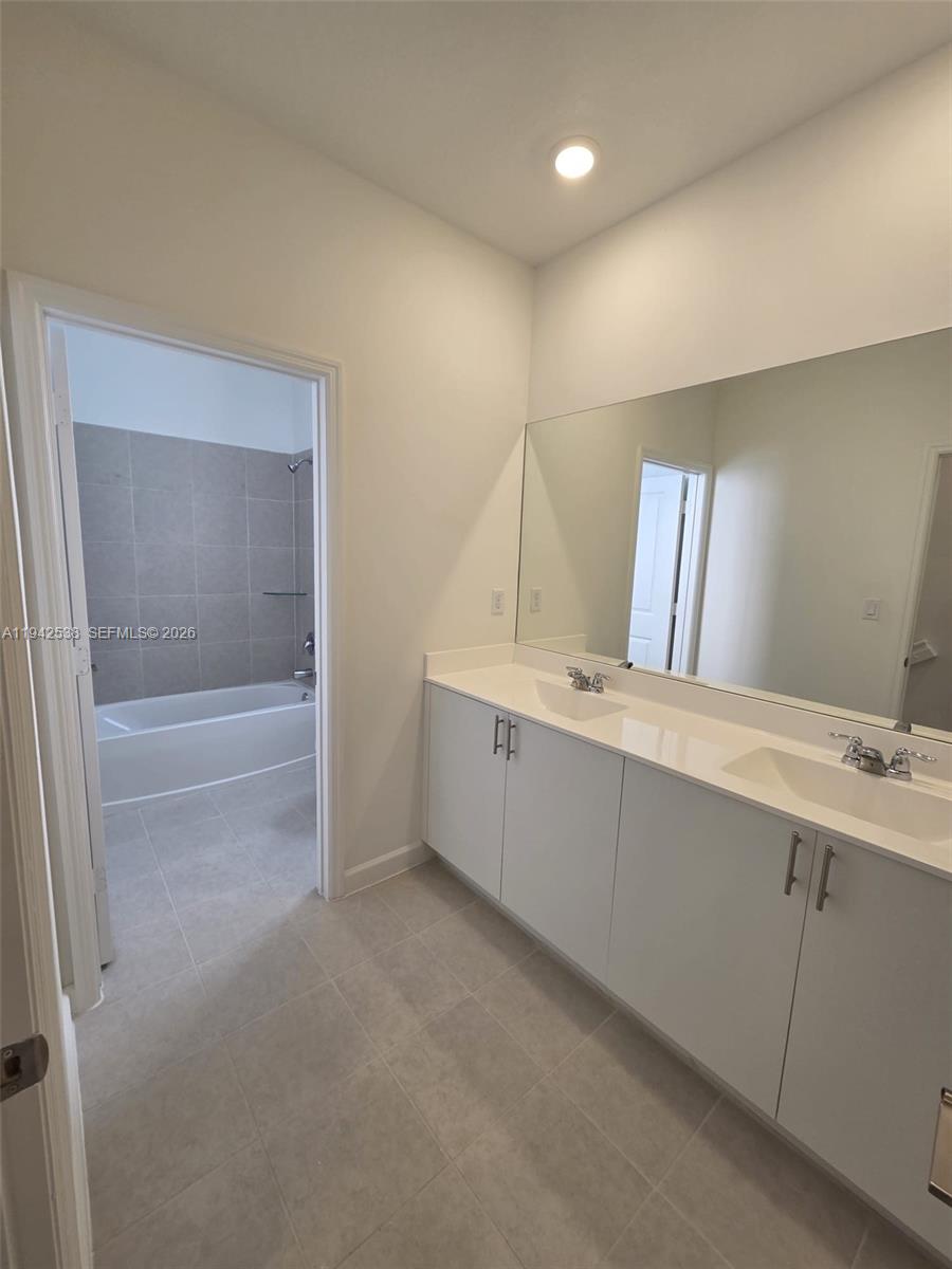 16303 Southwest 147th Place, Unit 16303 Miami, FL 33193 - Photo 18 of 37 a bathroom with a double vanity sink and mirror