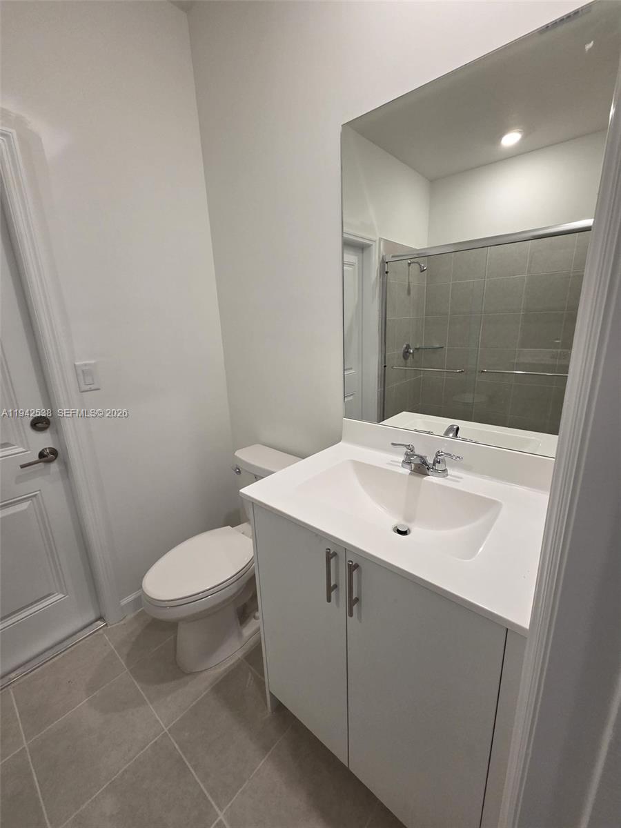 16303 Southwest 147th Place, Unit 16303 Miami, FL 33193 - Photo 25 of 37 a bathroom with a sink toilet and a mirror
