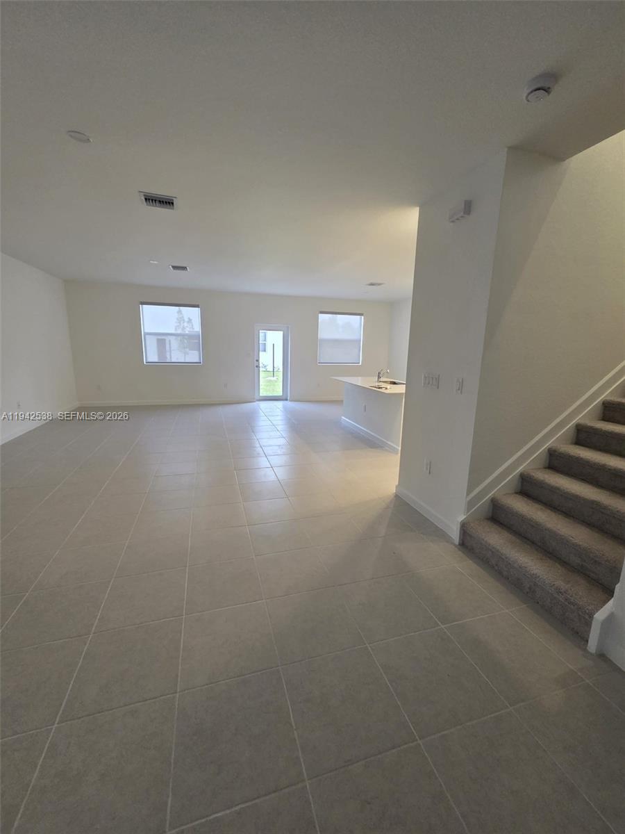 16303 Southwest 147th Place, Unit 16303 Miami, FL 33193 - Photo 6 of 37 a view of an empty room with stairs and a window