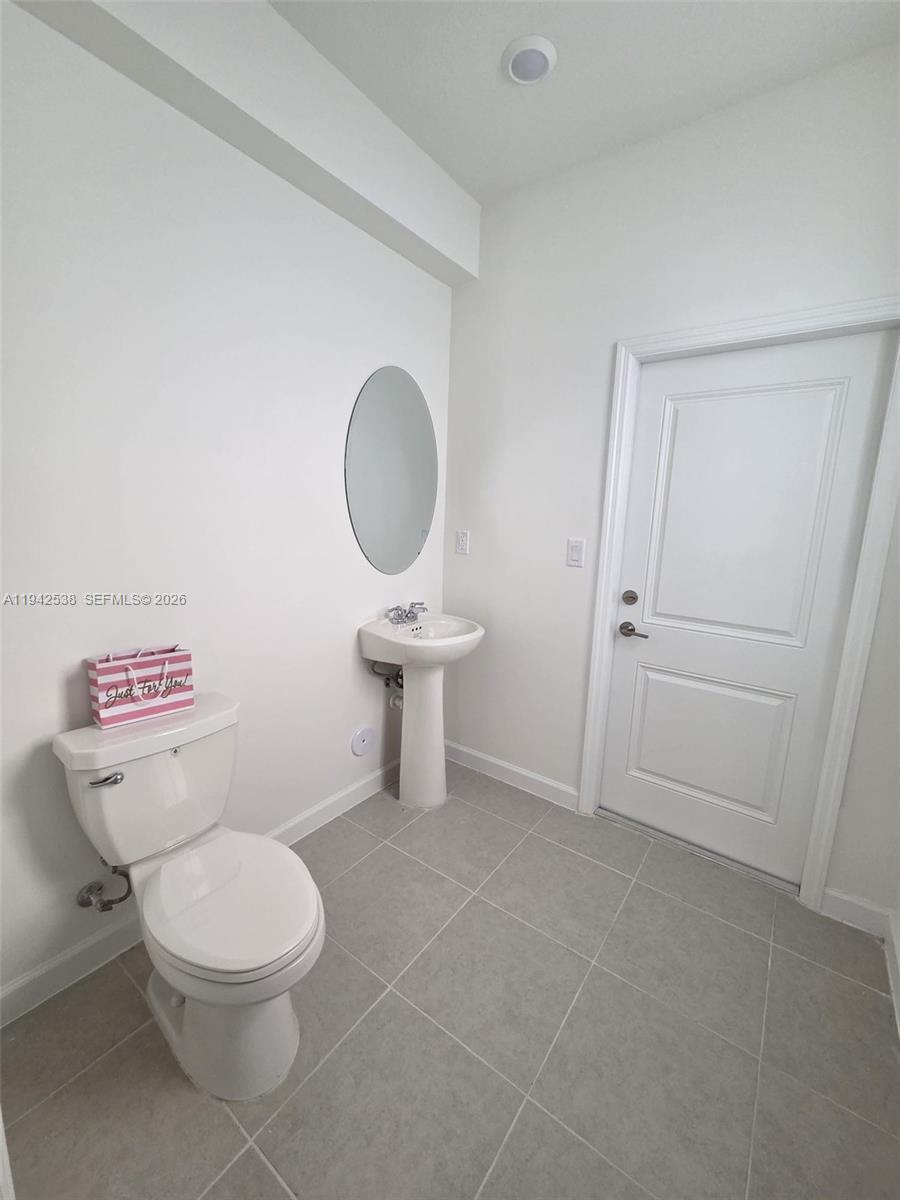 16303 Southwest 147th Place, Unit 16303 Miami, FL 33193 - Photo 7 of 37 a white toilet sitting next to a bathroom sink