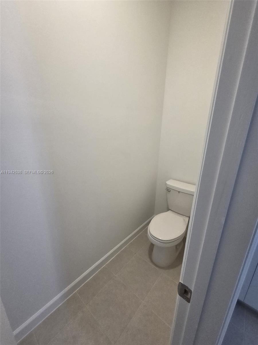 16303 Southwest 147th Place, Unit 16303 Miami, FL 33193 - Photo 10 of 37 a white toilet sitting next to a shower