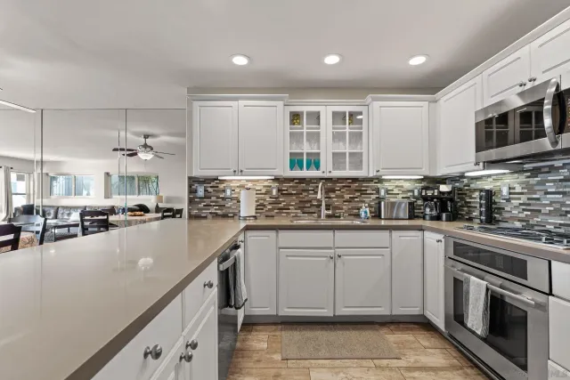 a kitchen with counter top space a sink stainless steel appliances and cabinets