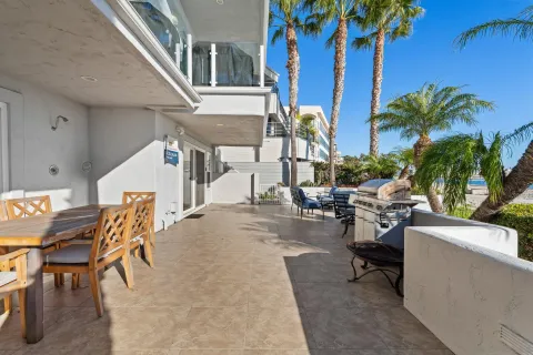 a view of a patio with dining table and chairs with plants and wooden fence