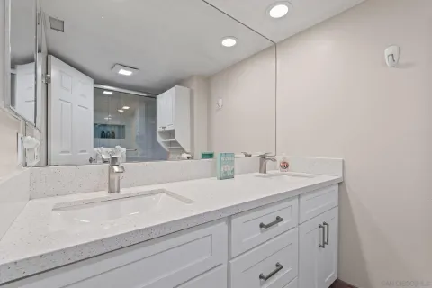 a bathroom with double vanity sink and a mirror