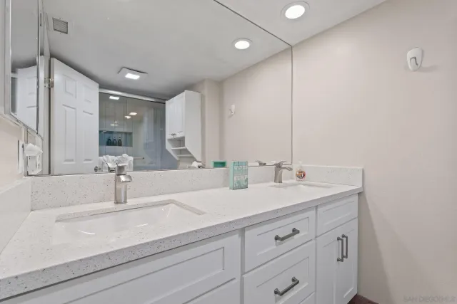 a bathroom with double vanity sink and a mirror