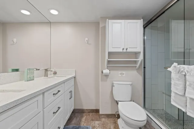 a bathroom with a toilet a sink and glass door
