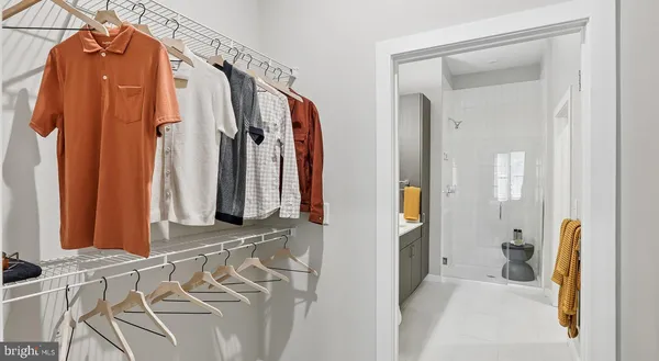 a bedroom with bed and a large mirror next to a window