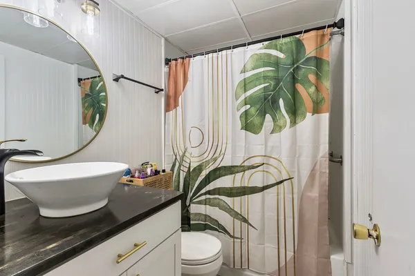 a bathroom with a granite countertop sink and a mirror