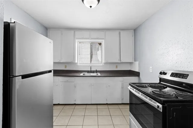 a kitchen with granite countertop a sink stove and refrigerator