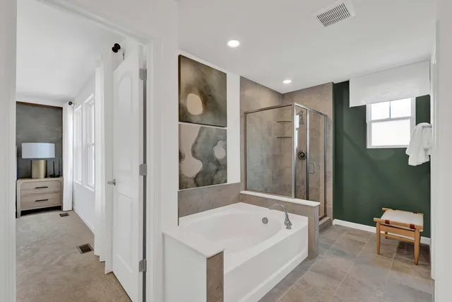 a bathroom with a tub a toilet and a shower