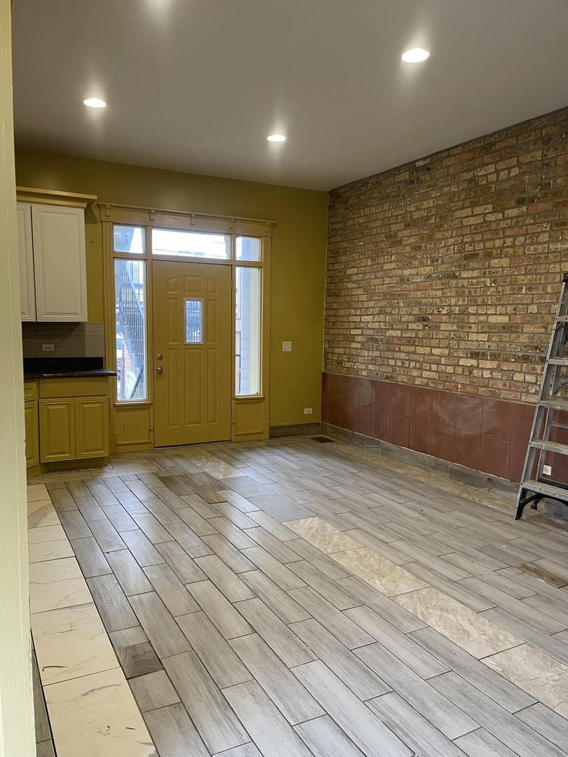 3341 West Walnut Street, Unit 1 Chicago, IL 60624 - Photo 2 of 10 an empty room with wooden floor and windows