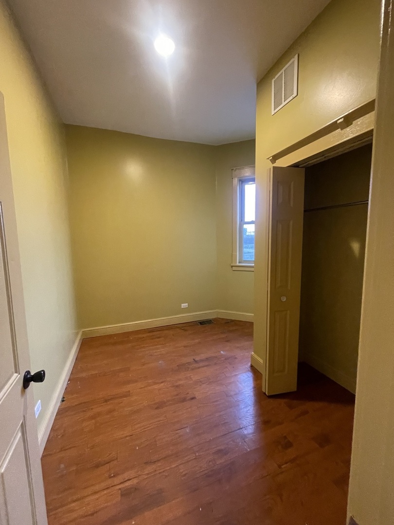 3341 West Walnut Street, Unit 1 Chicago, IL 60624 - Photo 6 of 10 an empty room with a fireplace and wooden floor