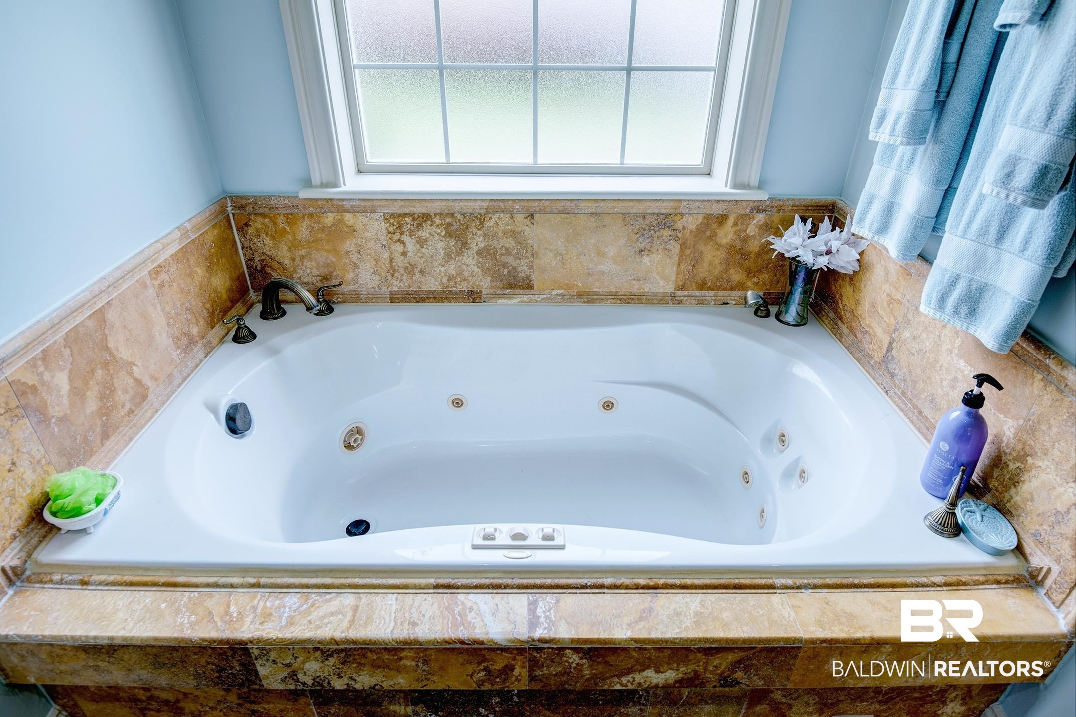 9357 Lakeview Drive Foley, AL 36535 - Photo 38 of 68 White jetted soaking tub with bronze-tone fixtures set into a tile surround
