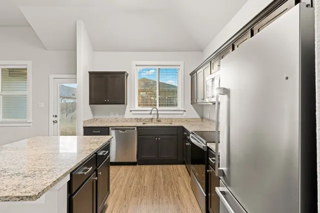 a large kitchen with a sink stove microwave and refrigerator