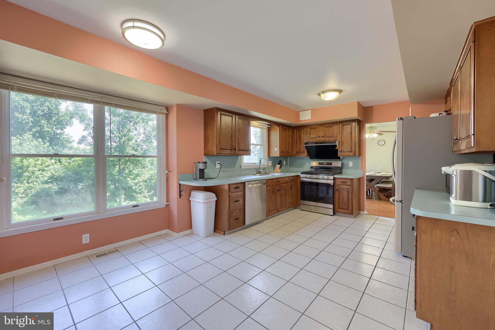 121 Sage Drive Reading, PA 19608 - Photo 14 of 47 a large kitchen with a large counter top stainless steel appliances a stove a sink cabinets and a dining table