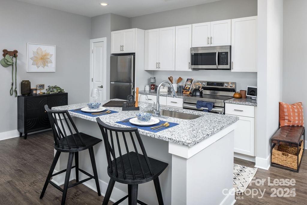 225 Rhyne Road, Unit A1 Charlotte, NC 28214 - Photo 37 of 48 a kitchen with stainless steel appliances kitchen island granite countertop a dining table chairs and a refrigerator