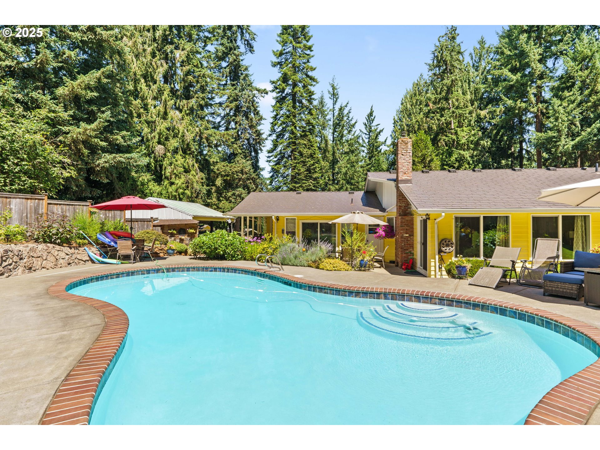 38754 Place Road Fall Creek, OR 97438 - Photo 32 of 48 a view of a swimming pool with lawn chairs under an umbrella