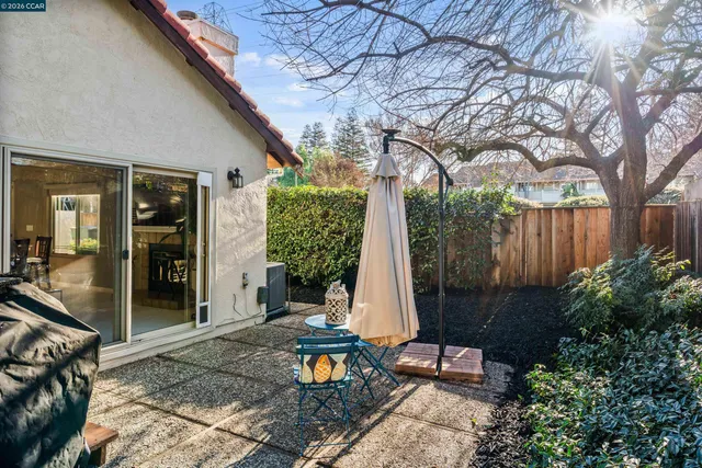a view of house with backyard and sitting area
