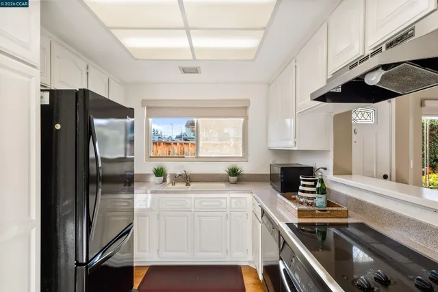 a kitchen with a refrigerator a sink and cabinets