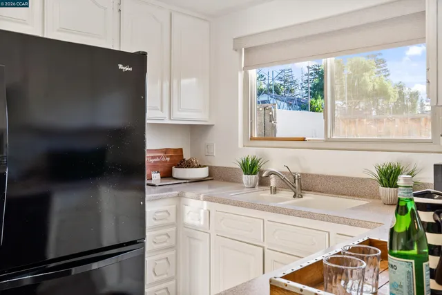 a kitchen with stainless steel appliances a sink a window and cabinets
