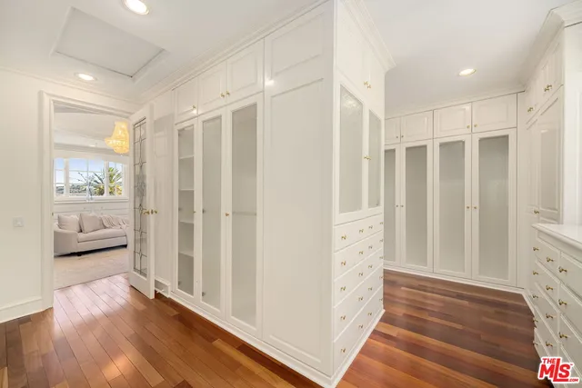 a bedroom with a large bed and wooden floor