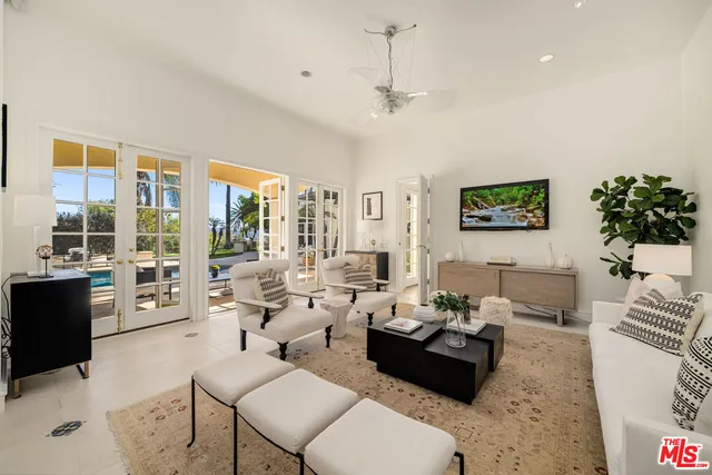 a view of a swimming pool with a lounge chair and palm trees