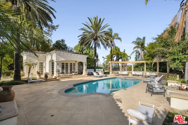 a view of a swimming pool with a patio and a garden