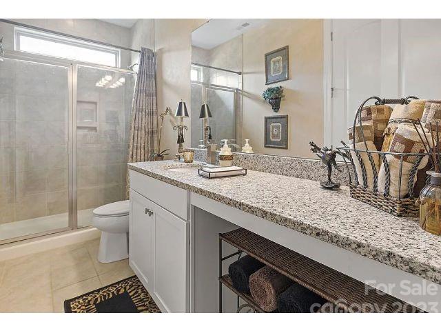1292 Independence Street Fort Mill, SC 29708 - Photo 24 of 39 a bathroom with a granite countertop sink a toilet and shower