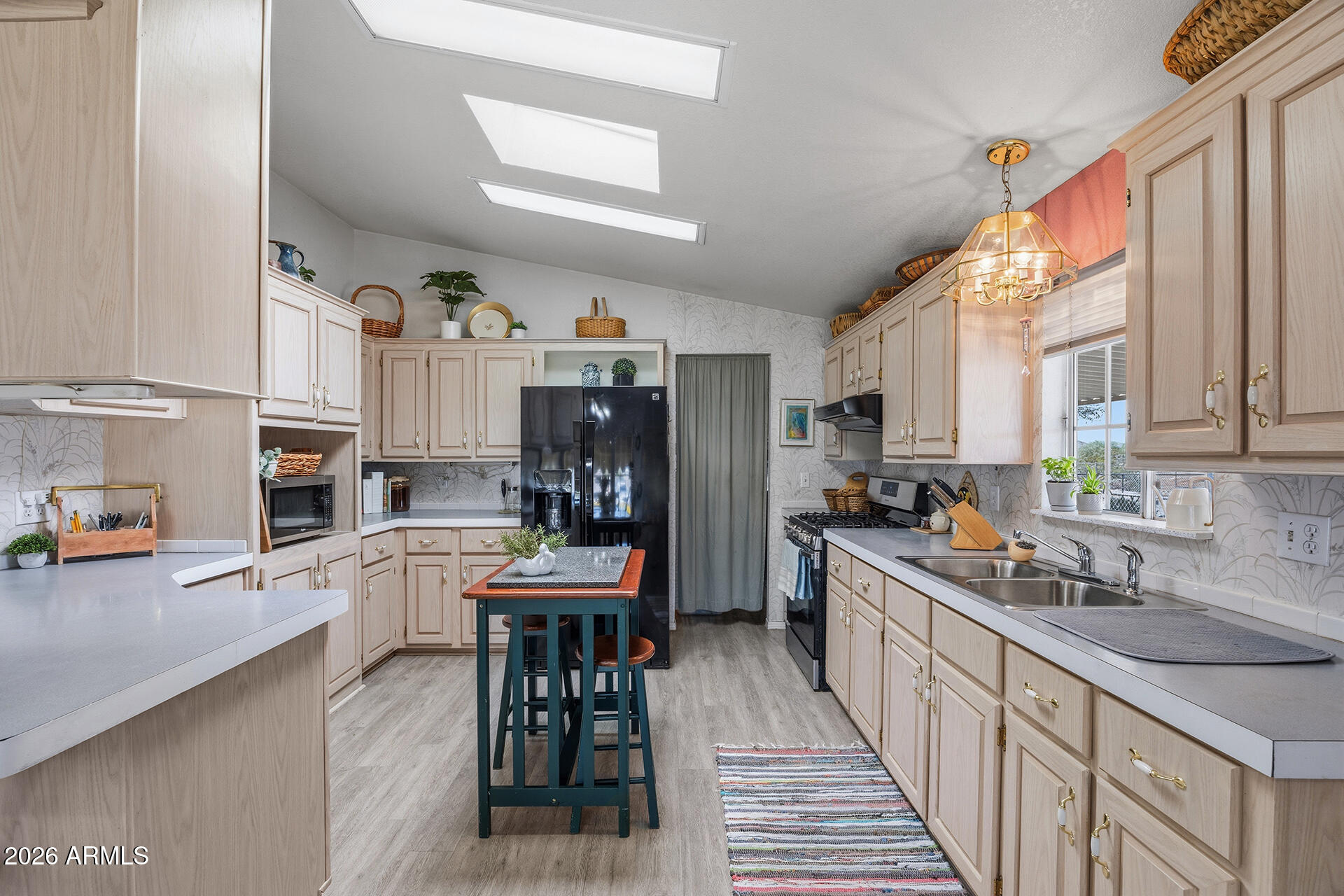 2701 East Utopia Road, Unit 153 Phoenix, AZ 85050 - Photo 13 of 26 a kitchen with stainless steel appliances a sink a stove a refrigerator cabinets and a dining table