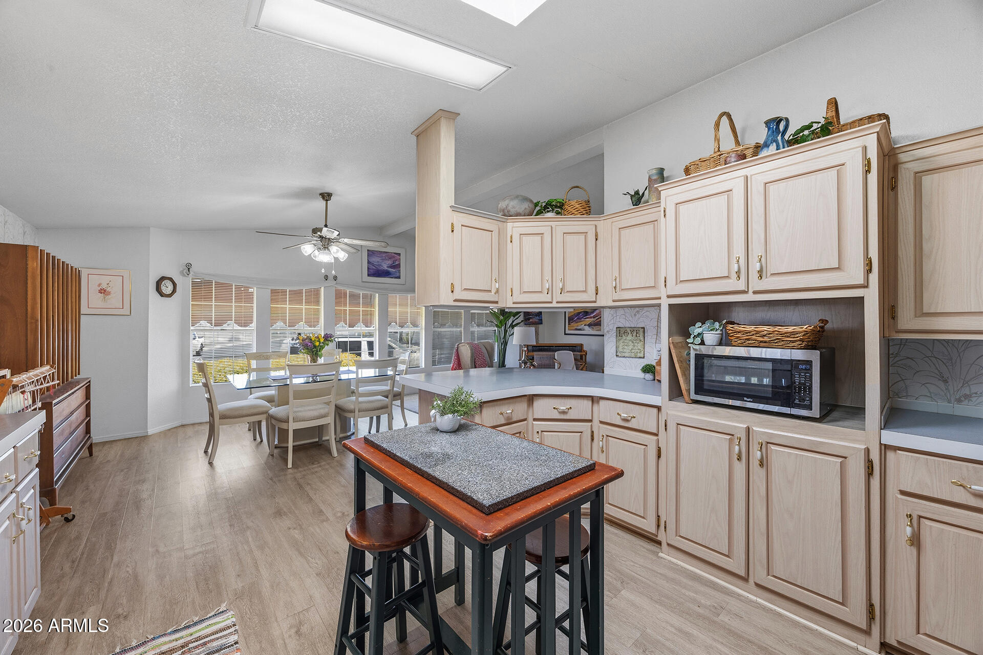 2701 East Utopia Road, Unit 153 Phoenix, AZ 85050 - Photo 14 of 26 a open kitchen with stainless steel appliances granite countertop a stove top oven a sink a dining table and chairs with wooden floor