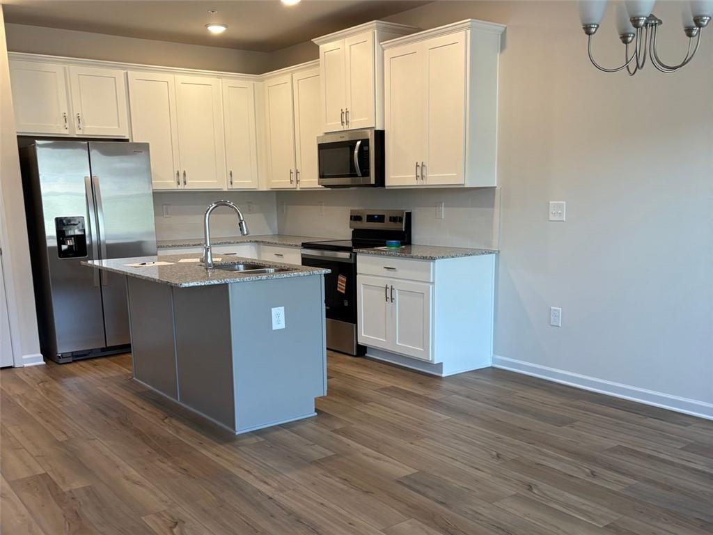 9440 Maple Grove Lane Jonesboro, GA 30238 - Photo 2 of 21 a kitchen with stainless steel appliances granite countertop a stove a sink and a microwave