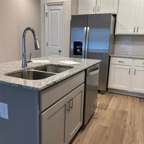 a kitchen with granite countertop a sink and cabinets