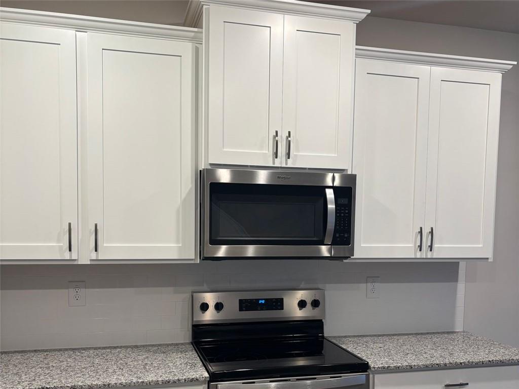 9440 Maple Grove Lane Jonesboro, GA 30238 - Photo 5 of 21 a kitchen with stainless steel appliances granite countertop white cabinets and a stove