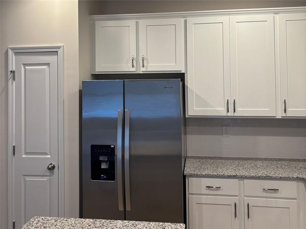 9440 Maple Grove Lane Jonesboro, GA 30238 - Photo 6 of 21 a kitchen with granite countertop a refrigerator and cabinets