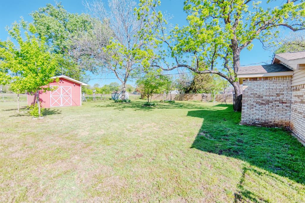 700 South Washington Street Pilot Point, TX 76258 - Photo 14 of 14 a backyard of a house with lots of green space and fountain