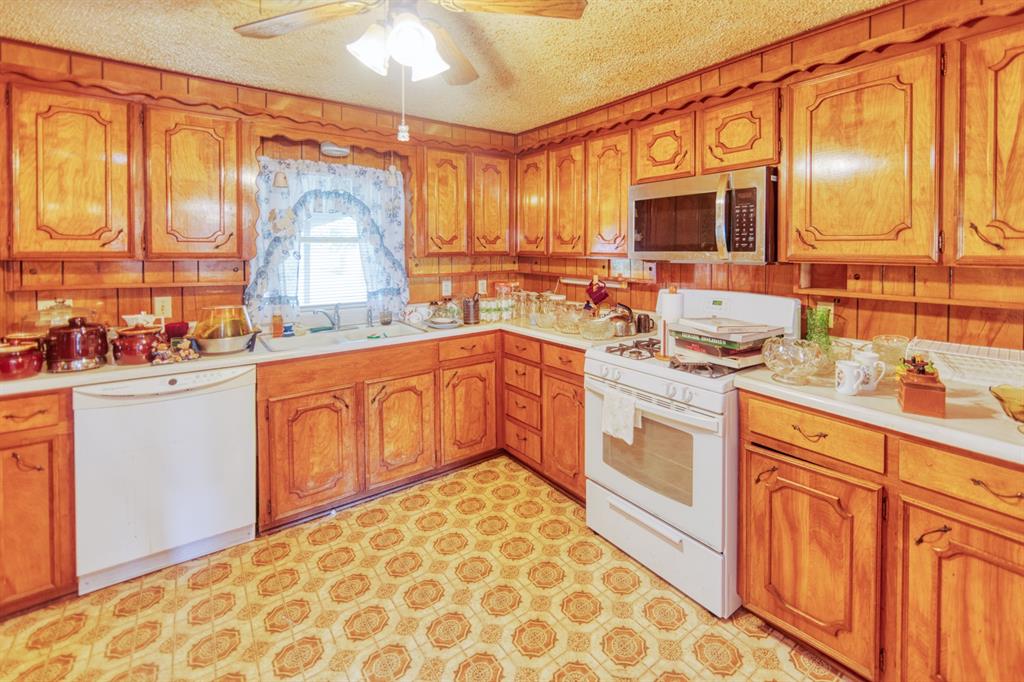 700 South Washington Street Pilot Point, TX 76258 - Photo 5 of 14 a kitchen with stainless steel appliances a sink stove and cabinets
