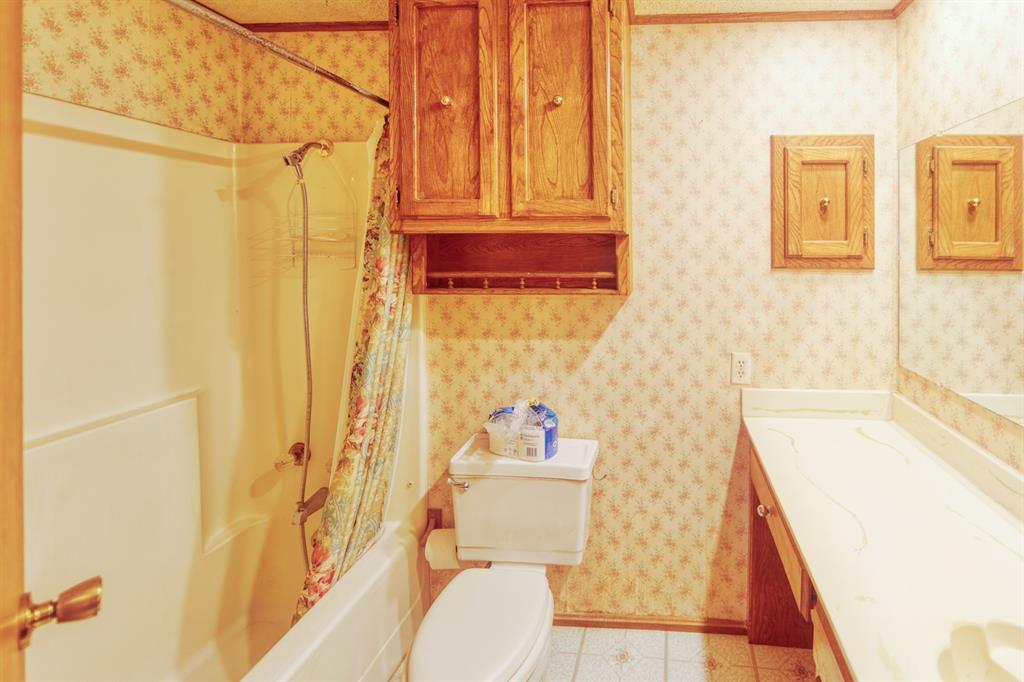 700 South Washington Street Pilot Point, TX 76258 - Photo 8 of 14 a bathroom with a sink and a shower curtain