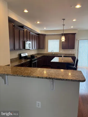 a kitchen with stainless steel appliances granite countertop wooden cabinets a stove top oven a sink and dishwasher