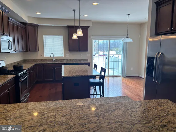 a kitchen with wooden floors and a granite counter top