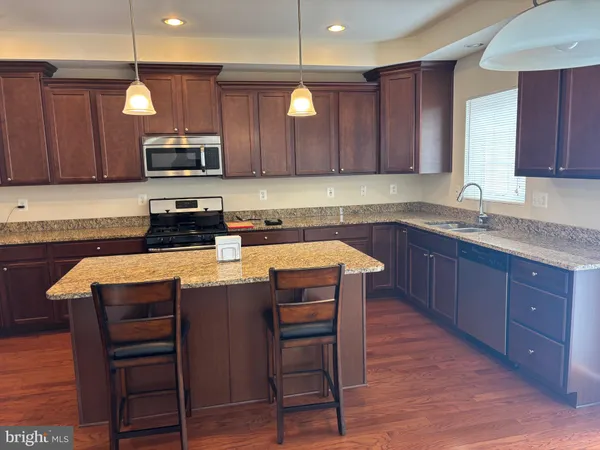 a kitchen with stainless steel appliances granite countertop a refrigerator and a stove top oven