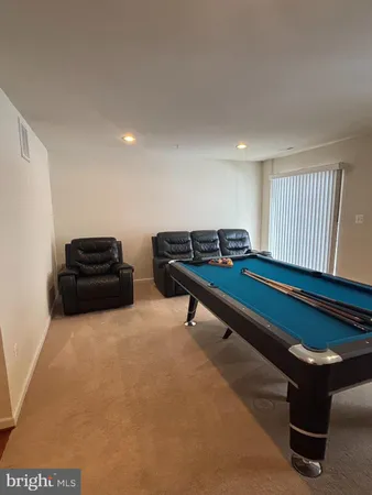 a room with furniture pool table and windows