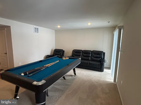 a room with furniture pool table and rug